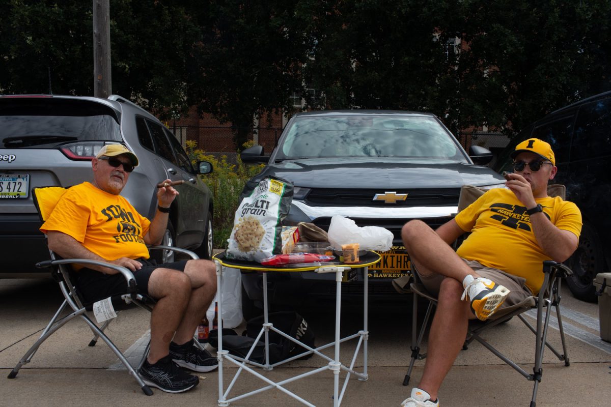 Hawkeye fans Richard and Andy smoke cigars before a football game between No. 25 Iowa and Western Michigan in Iowa City on Saturday, Sept. 16, 2023.