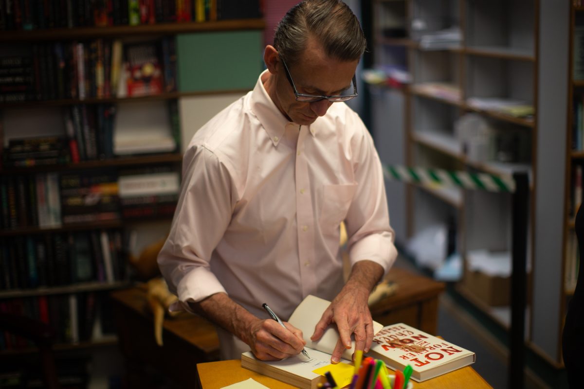Chuck+Palahniuk+signs+a+copy+of+his+new+book+Not+Forever%2C+But+For+Now+at+Prairie+Lights+in+Iowa+City+on+Thursday%2C+Sept.+21%2C+2023.+Palahniuk+is+a+novelist+publishing+fiction%2C+nonfiction%2C+and+adult+coloring+books.