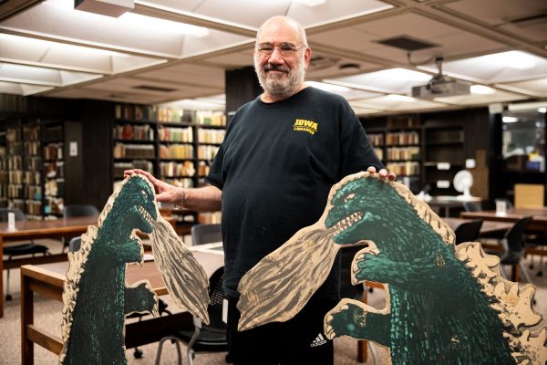 Curator of Science Fiction and Popular Culture Collections Peter Balestrieri holds Godzilla cutouts from the mid 1900s at the special archives in the University of Iowa Main Library on Sept. 22, 2023. Balestrieri explained that the archives holds 400 20th Century Fox scripts spanning from the 1920s to 1970s 