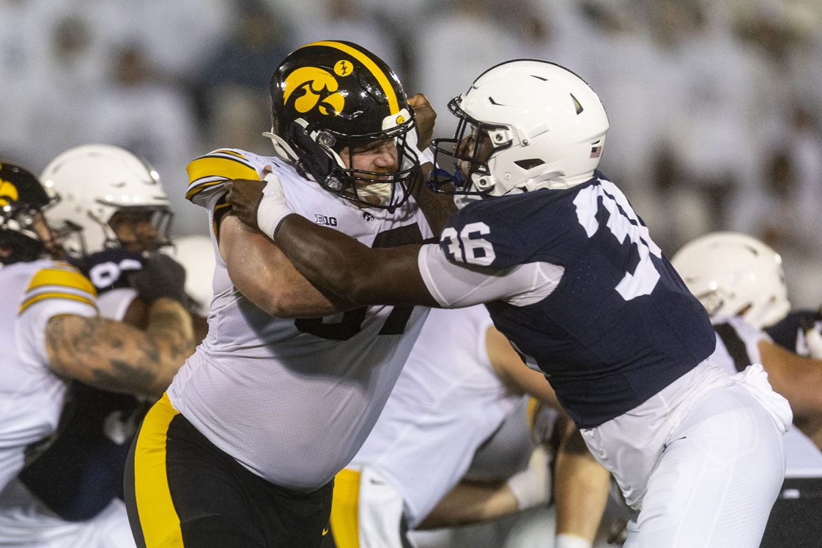 Iowa offensive lineman Gennings Dunker blocks Penn State defensive end Zuriah Fisher during a football game between No. 24 Iowa and No. 7 Penn State at Beaver Stadium in State College, Pa., on Saturday, Sept. 23, 2023. The Nittany Lions defeated the Hawkeyes, 31-0. (Ayrton Breckenridge/The Daily Iowan)