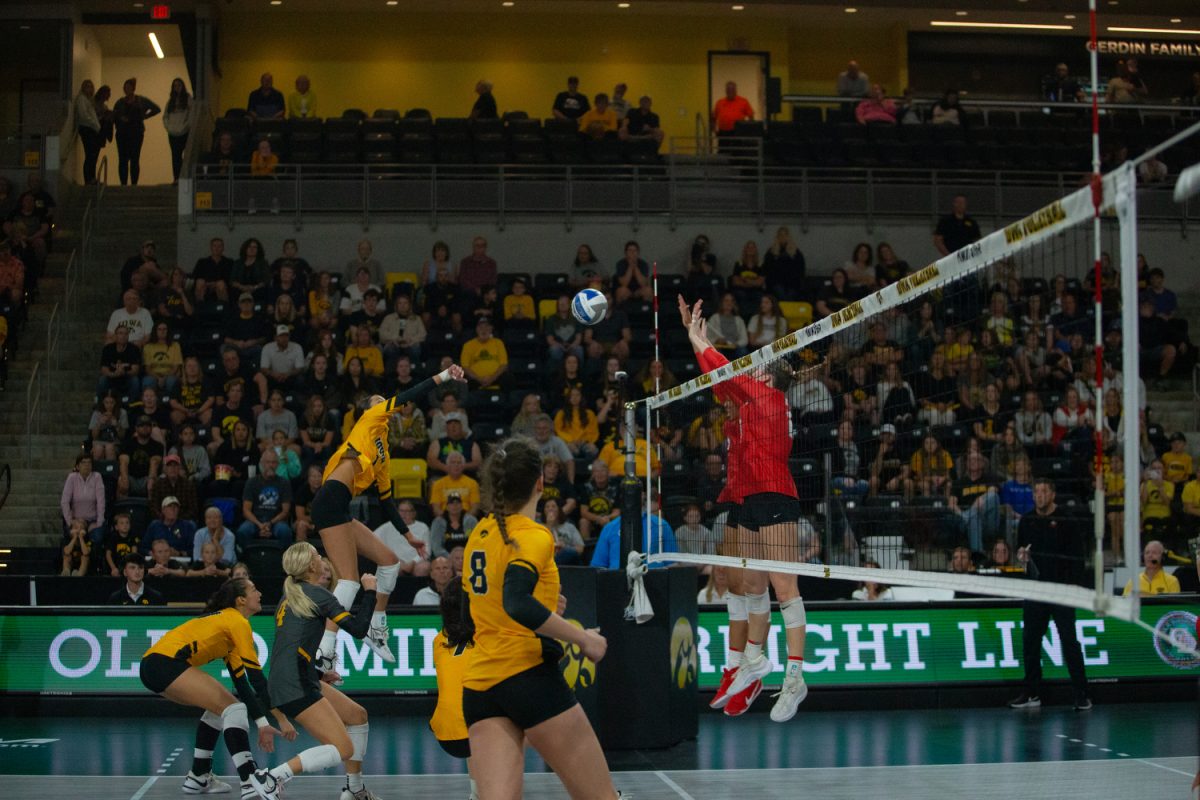 No. 1, Nataly Moravec jumps to hit the ball while being covered by her team, through Ohio States block at the Xtreme Arena in Coralville on Sept 24. 2023. 