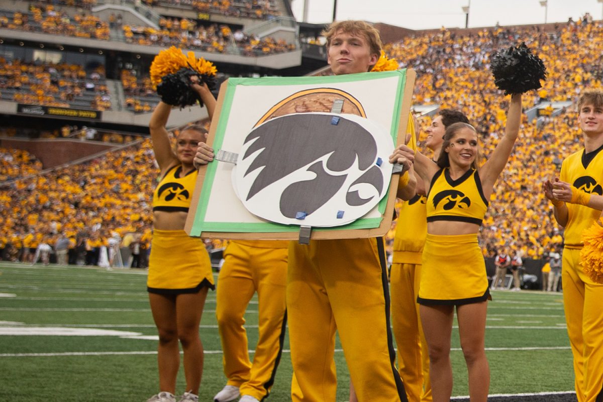 Iowa Spirit Squad member Austin Beam Holds a sign at a football Game between Iowa and Western Michigan on Saturday, Sept. 16, 2023. 