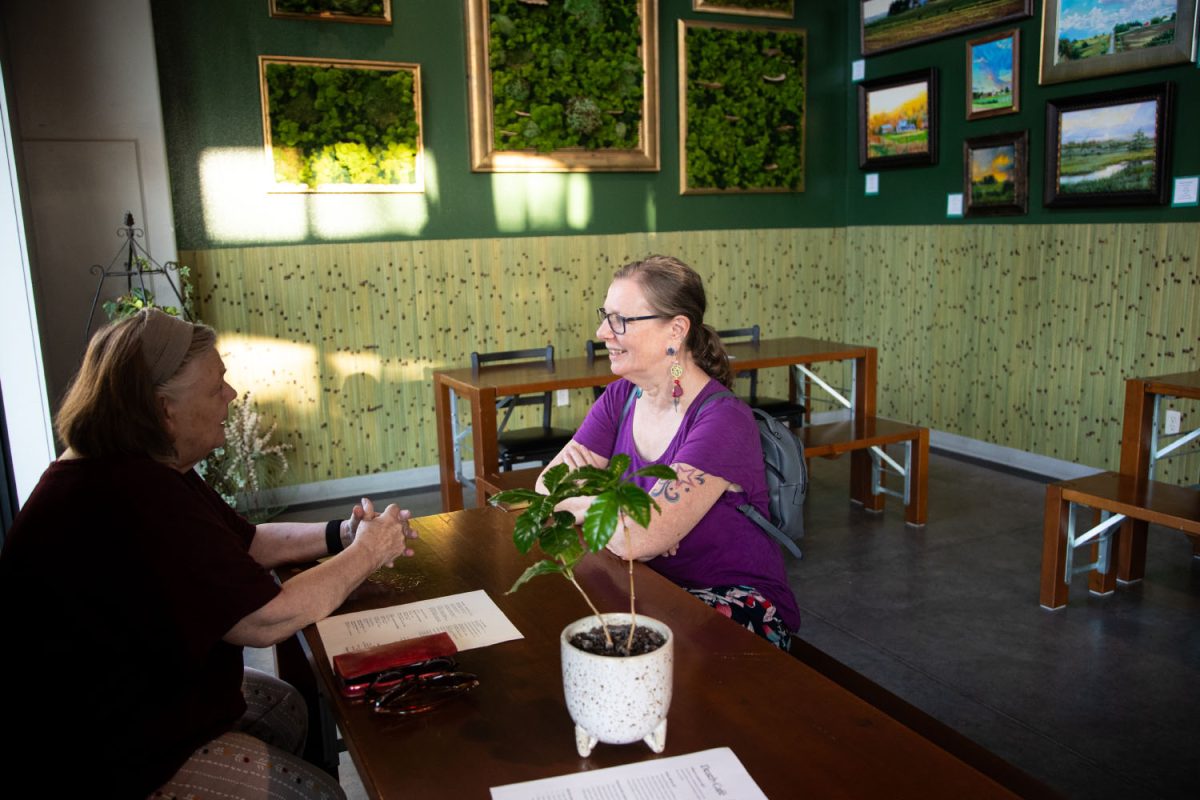 Mary McCall and Carol MacVey hold a conversation during the Death Cafe meeting at The Green House in Iowa City on Friday, Aug. 29, 2023. 
