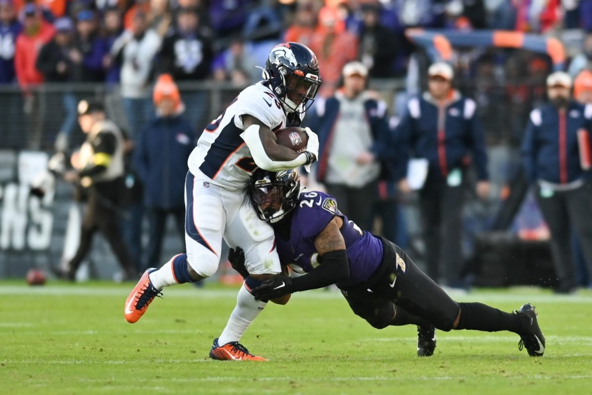Dec 4, 2022; Baltimore, Maryland, USA; Denver Broncos running back Mike Boone (26) is hit by Baltimore Ravens safety Geno Stone (26) during the second half at M&T Bank Stadium. (Tommy Gilligan USA TODAY Sports)