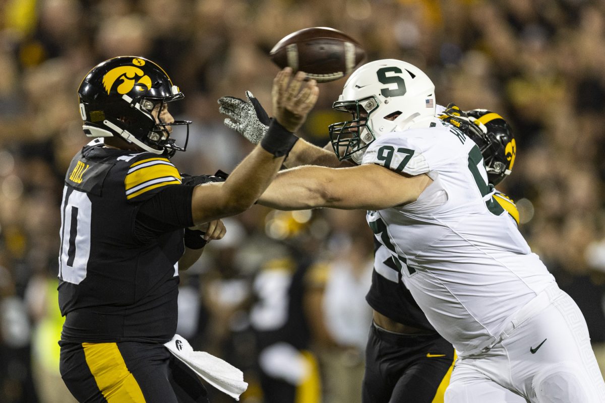 Iowa quarterback Deacon Hill throws the ball as Michigan State defensive lineman Maverick Hansen applies pressure during a football game between Iowa and Michigan State at Kinnick Stadium on Saturday, Sept. 30, 2023. The Hawkeyes defeated the Spartans, 26-16. Hill had one touchdown and one interception.