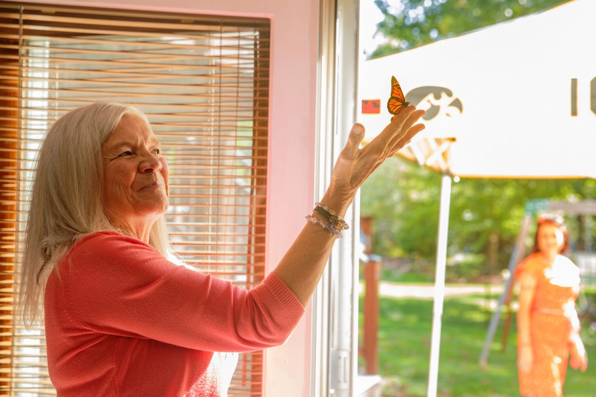 Merrilee Ramsey releases a butterfly during the Iowa City Sober Living women’s home opening in Iowa City on Sunday, Oct. 1, 2023.