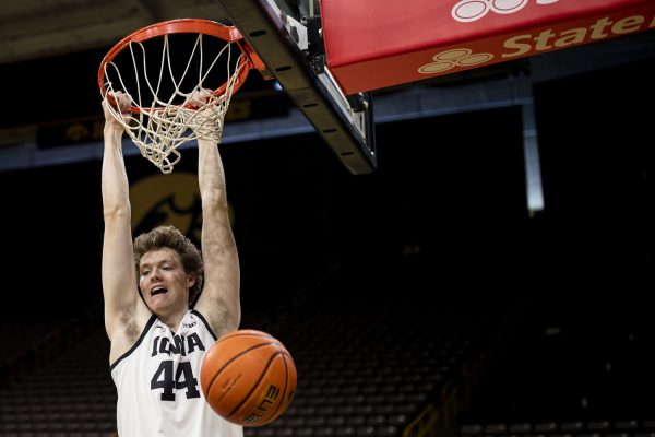 Iowa forward Riley Mulve hangs on the basketball hoop after a dunk during the 2023 Men’s Basketball media day at Carver-Hawkeye Arena on Monday Oct. 2, 2023. McCaffery has coached Iowa for 13 years and is the Big Ten’s third longest tenured head coach.
