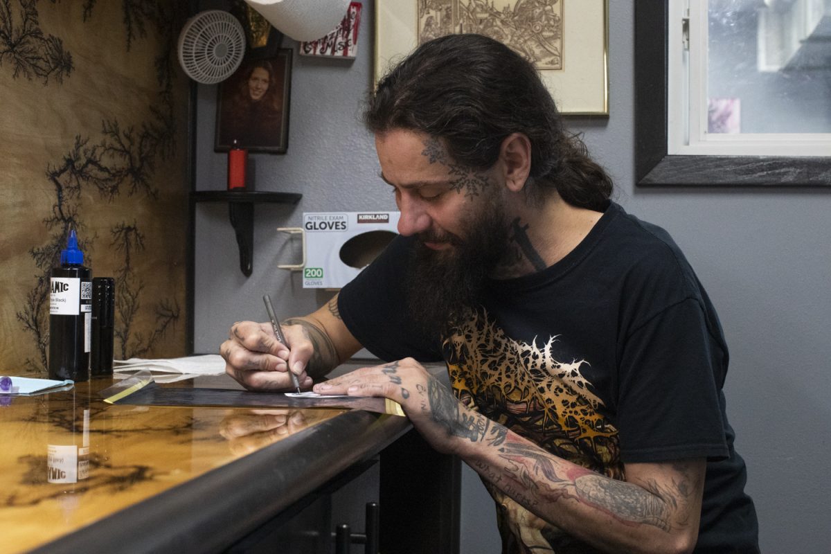Iowa City based tattoo artist David Rich draws a stencil for Mori Venus at Golden Tattoo & Piercing in Iowa City on Monday, Oct. 10, 2023. Venus was not getting a scar covered, Rich has worked with clients looking for that service in Iowa City.