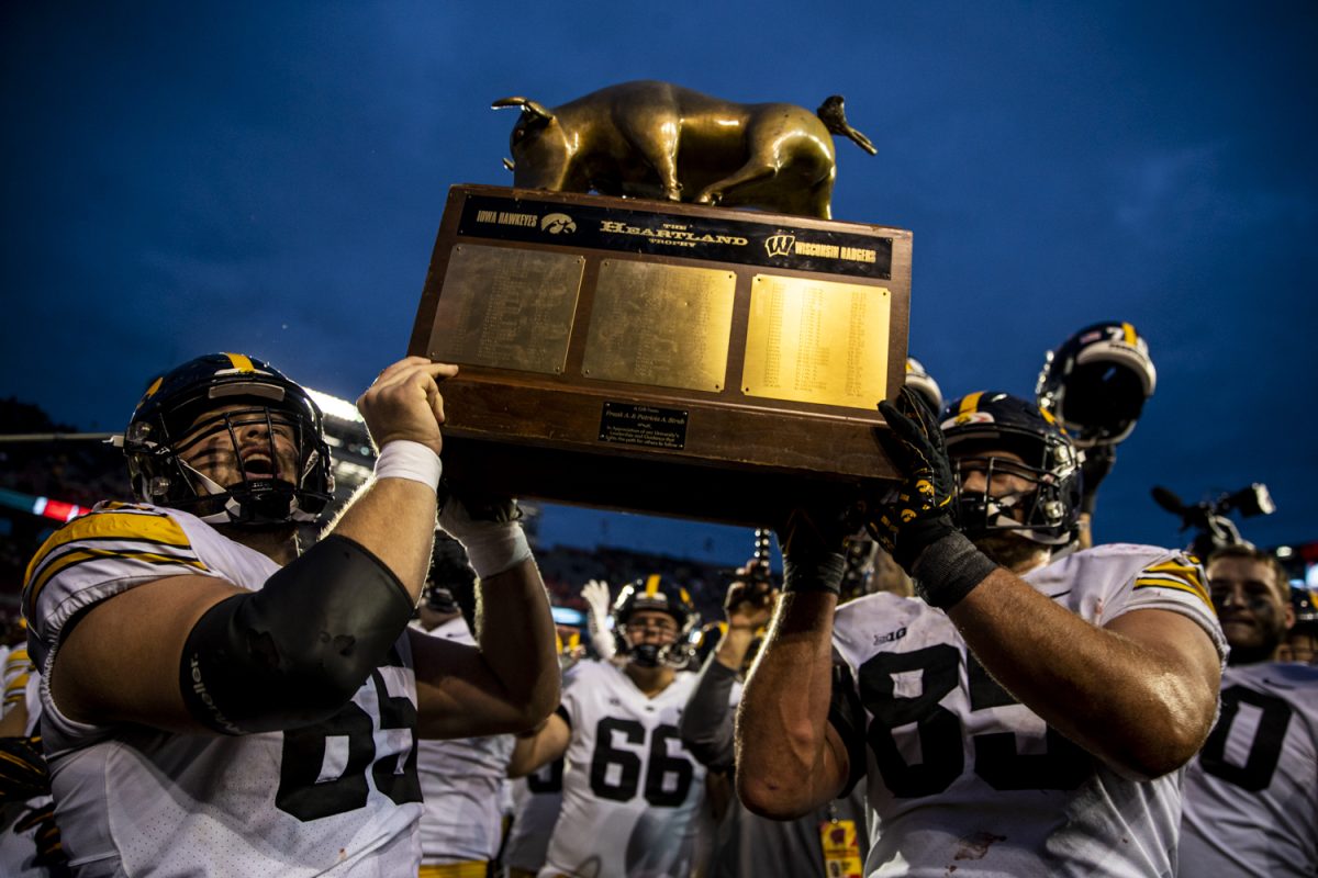 Iowa offensive lineman Logan Jones and defensive lineman Logan Lee hold the Heartland Trophy after a football game between Iowa and Wisconsin at Camp Randall Stadium on Saturday, Oct. 14, 2023. The Hawkeyes defeated the Badgers, 15-6.