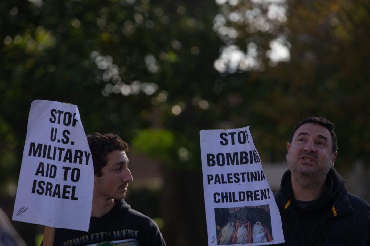 Pro-Palestine protesters hold up signs to passing cars on the Pentacrest in Iowa City on Sunday, Oct. 15, 2023. The Israel-Hamas War started on Oct. 7.