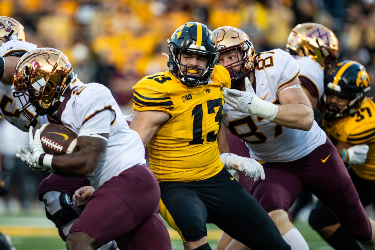 Iowa defensive end Joe Evans tries to tackle Minnesota running back Sean Tyler during a football game between No. 24 Iowa and Minnesota at Kinnick Stadium in Iowa City on Saturday, Oct. 21, 2023. Tyler had 23 rushing yards. The Golden Gophers defeated the Hawkeyes, 12-10.