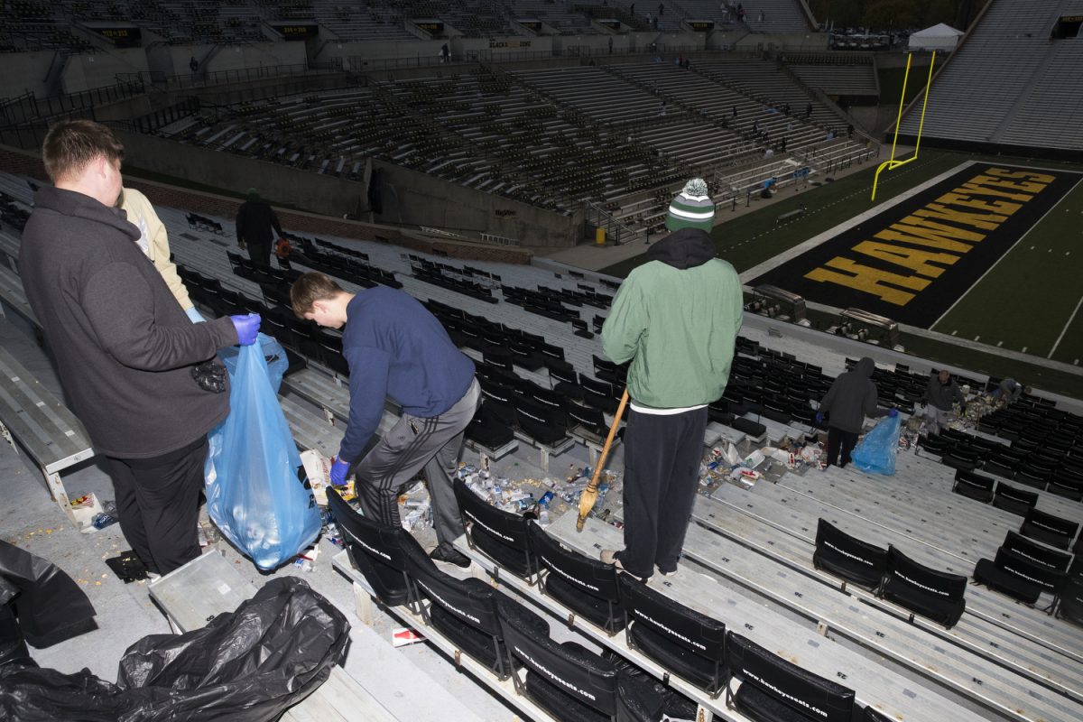 Iowa City Community School District students clean up Kinnick Stadium on Sunday, Oct. 22, 2023. The cleanup operation at Kinnick is a partnership between the Iowa City Athletics Booster Club and the University of Iowa, where students clean Kinnick Stadium after gameday for athletic booster club funding. Part of the operation includes sweeping trash into the aisles of Kinnick.