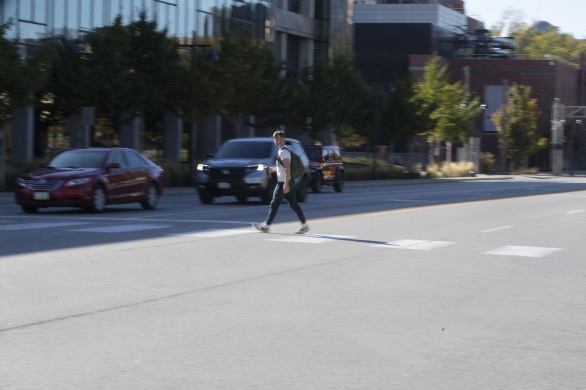 A pedestrian walks across West Burlington Street in Iowa City on Sunday, Oct. 22, 2023. According to a city report, Iowa City has fewer pedestrian and vehicle collisions than state and national averages.