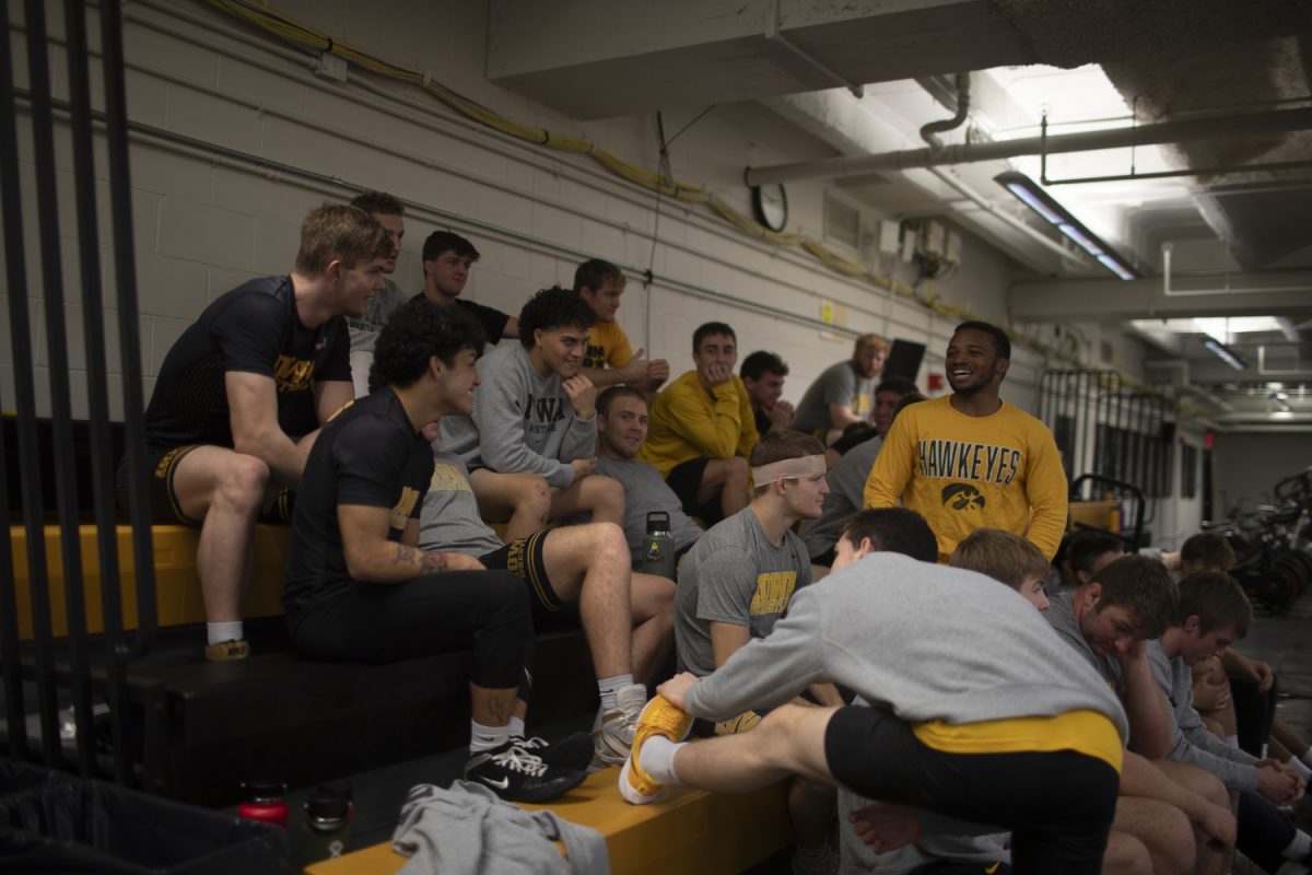 The Iowa mens wrestling team talk and stretch on the bleachers during the Iowa mens wrestling media day at Carver-Hawkeye Arena on Thursday, Oct. 26, 2023.