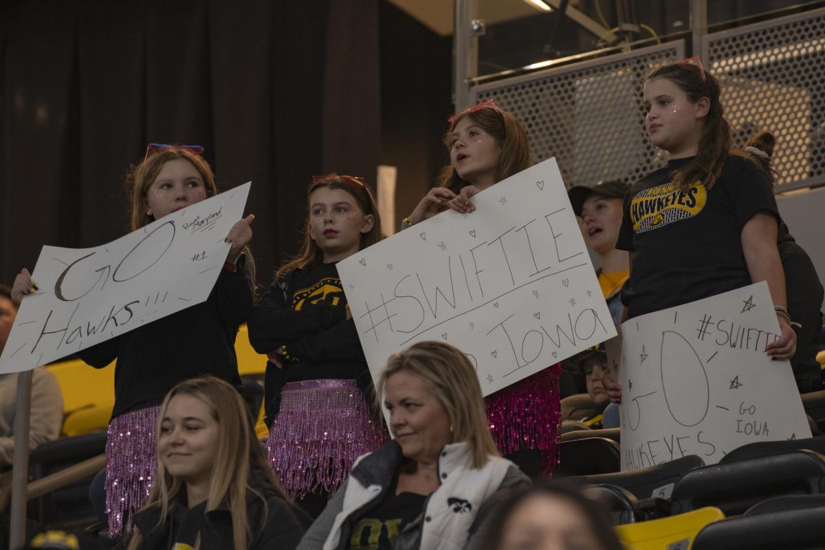 Hawkeye fans hold posters for Taylor Swift night during a volleyball match between Maryland and Iowa at Xtream Arena in Coralville on Oct. 28, 2023. The Terrapins defeated the Hawkeyes 3-0.