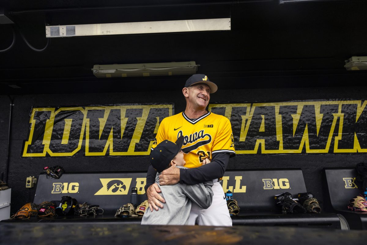 Liam Doxsee, 9, hugs Iowa head baseball coach Rick Heller before a baseball game at Duane Banks Field in Iowa City on Thursday, Sept. 21, 2023. Between attending a few baseball practices and most games and joining in on pregame huddles, Liam’s mother Mary Matheson said Liam treats this opportunity as a job, enjoying every second of it. Liam sits on a bench in the dugout, rolling around a baseball that’s wet from the rain. After the athletes warm up, they make their way through the dugout, high-fiving and eagerly exchanging hellos with Liam.