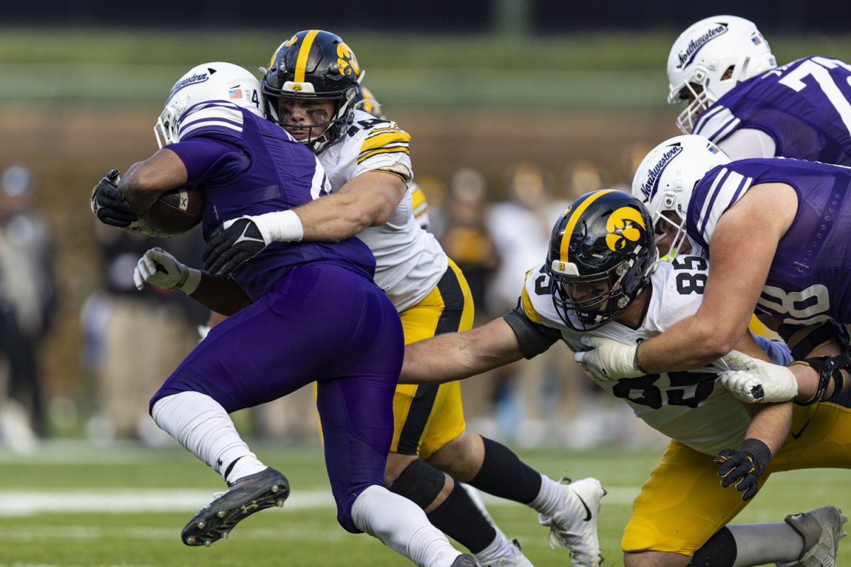 Iowa defensive lineman Ethan Hurkett tackles Northwestern running back Cam Porter during the 2023 Wildcats Classic a football game between Iowa and Northwestern at Wrigley Field in Chicago on Saturday, Nov. 4, 2023. (Ayrton Breckenridge/The Daily Iowan)