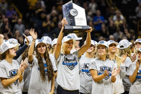 Iowa defender Sam Cary hoists the Big Ten Trophy as Iowa soccer gets recognized during a home opener basketball game between No. 3 Iowa and Fairleigh Dickinson at Carver-Hawkeye Arena on Monday, Nov. 6, 2023. The Hawkeyes, defeated the Knights, 102-46. 