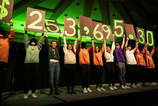 Members raise posters showing the final amount raised during the University of Iowa Dance Marathon’s “Day to Dance Marathon” Power Hour at the Iowa Memorial Union in Iowa City on Tuesday, Nov. 7, 2023. The organization raised $253,695.30 during its 24-hour fundraising event. 