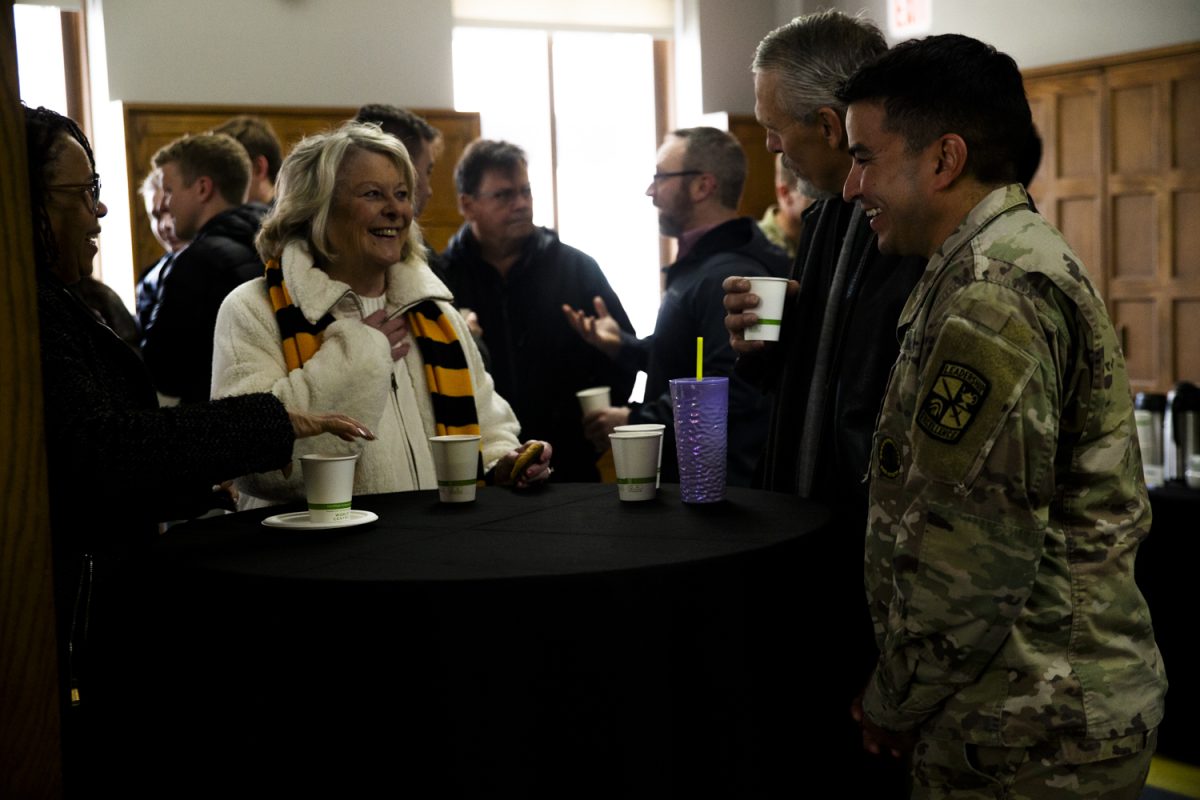 Veterans and event goers hold a conversation at the reception after the University of Iowa Veterans Plaza Dedication at the Iowa Memorial Union in Iowa City on Friday, Nov. 10, 2023.