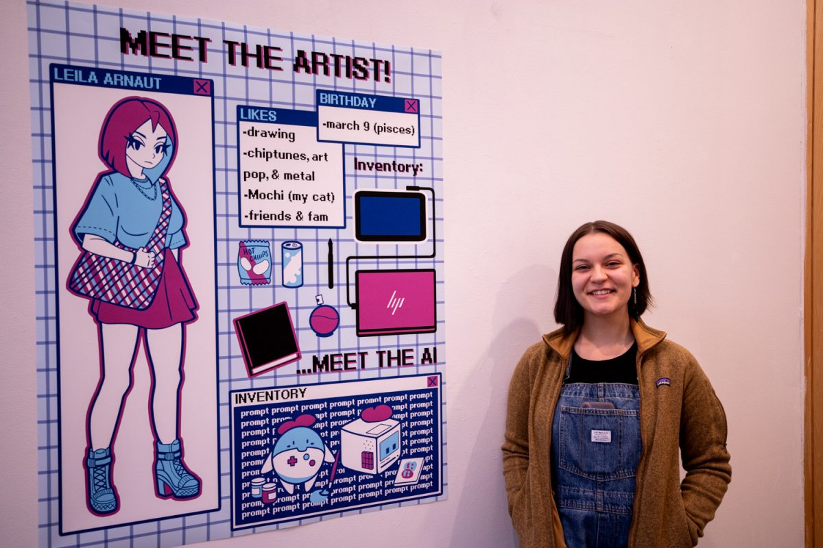 Leila Arnaut poses for a portrait next to one of her pieces of art during her BFA Exhibition “Byte the Dust” in the Visual Arts Building on the University of Iowa campus in Iowa City on Thursday, Nov. 9, 2023.