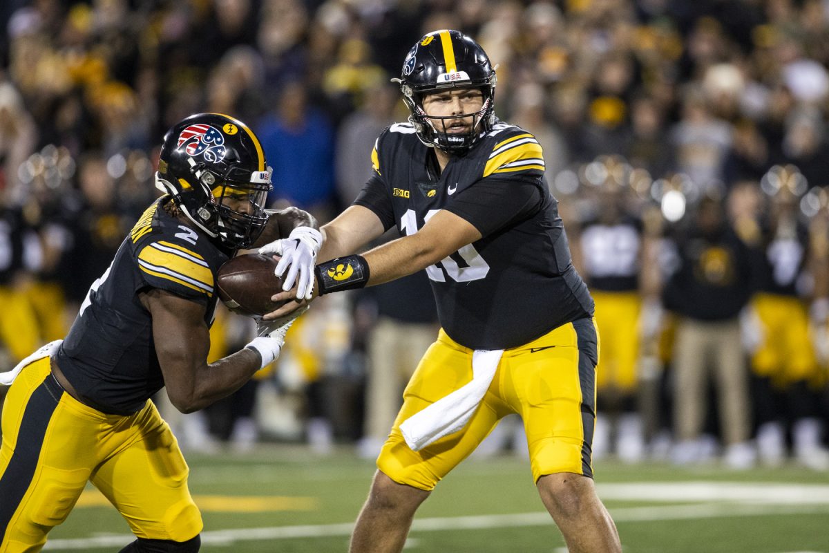 Iowa quarterback Deacon Hill hands off the ball to Iowa running back Kaleb Johnson during a football game between Iowa and Rutgers at Kinnick Stadium on Saturday, Nov. 11, 2023. Johnson carried the ball 10 times for 54 yards. The Hawkeyes defeated the Scarlet Knights, 22-0.