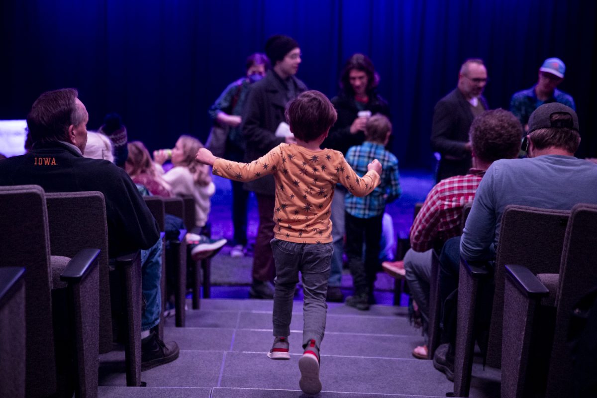 A child skips between the middle aisle at intermission during “Oh My Gourd!” a Playmaker performance hosted by Riverside Theatre in Iowa City on Saturday, Nov. 11, 2023.