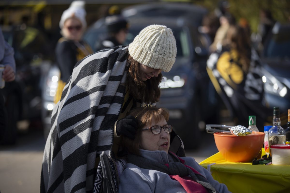 Sydney Roth puts a headband on Nancy Burns while tailgating in the University Of Iowa main Library Parking lot on Saturday, Nov. 11, 2023. The Hawks will play the Scarlet Knights, kicking off at 2:30. 