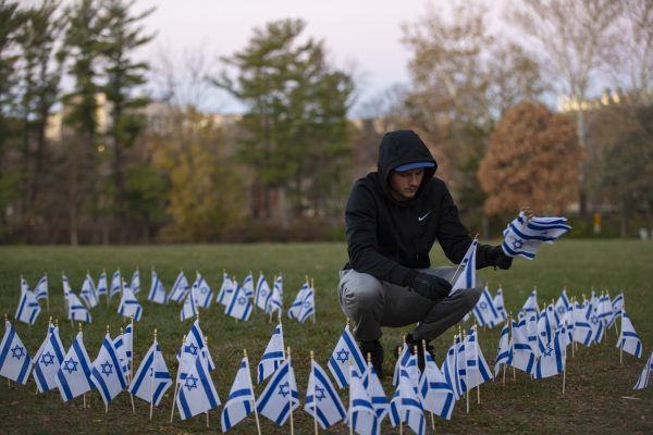 Calvin Moulton places flags in the shape of a star at a Young Americans for Freedom display of Israeli flags at Hubbard Park in support of Israeli hostages on Monday, Nov. 13, 2023. Members of the organization gathered at Hubbard Park to set up at 6 a.m. The display will be up all all day ending with the vigil at 6 p.m. 