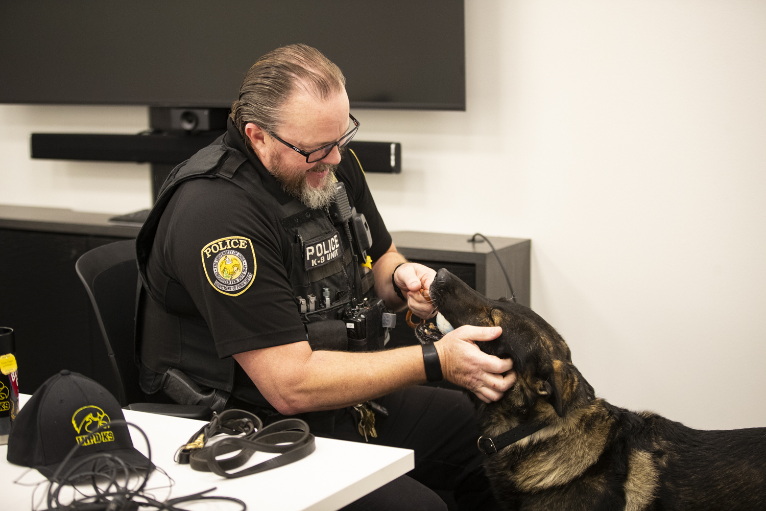 University of Iowa Police Department Officer Jess Bernard pets K9 Jago at the Campus Safety space in University Capitol Centre on Friday, Nov. 17, 2023. Jago is set to retire after 10 years of service.