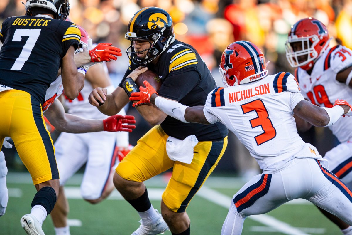 Iowa quarterback Deacon Hill carries the ball during a football game between Iowa and Illinois at Kinnick Stadium on Saturday, Nov. 18, 2023. Hill passed for 167 yards. The Hawkeyes defeated the Fighting Illini, 15-13.