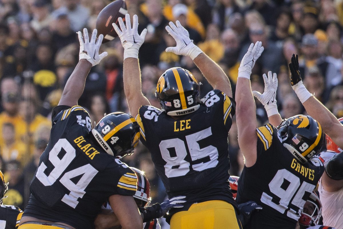 Iowa+football+defensive+linemen+reach+for+the+ball+during+a+football+game+between+Iowa+and+Illinois+at+Kinnick+Stadium+in+Iowa+City+on+Saturday%2C+Nov.+18%2C+2023.+The+Hawkeyes+defeated+the+Fighting+Illini%2C+15-13.