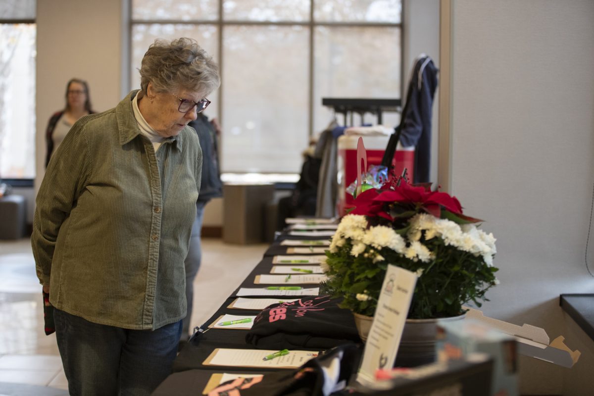 An attendee looks at the silent auction during the Holiday Thieves Market on Saturday, Dec. 9, 2023 at the Hyatt Regency Hotel & Conference Center Expo Hall In Coralville.