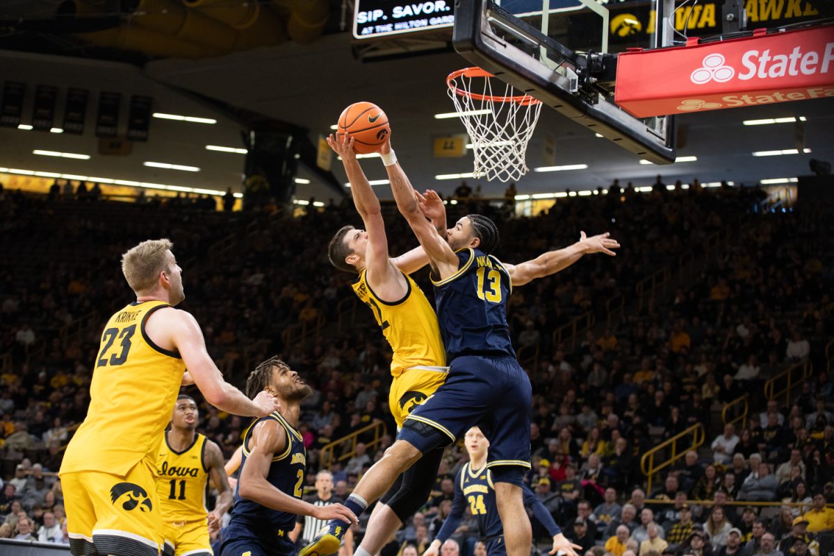 Michigan Forward Olivier Nkamhoua blocks Iowa’s Patrick McCaffery’s shot during a men’s basketball game between Iowa and Michigan. The Wolverines beat the Hawkeyes, 90-80. Nkamhoua had ten rebounds and scored 12 points during the game.