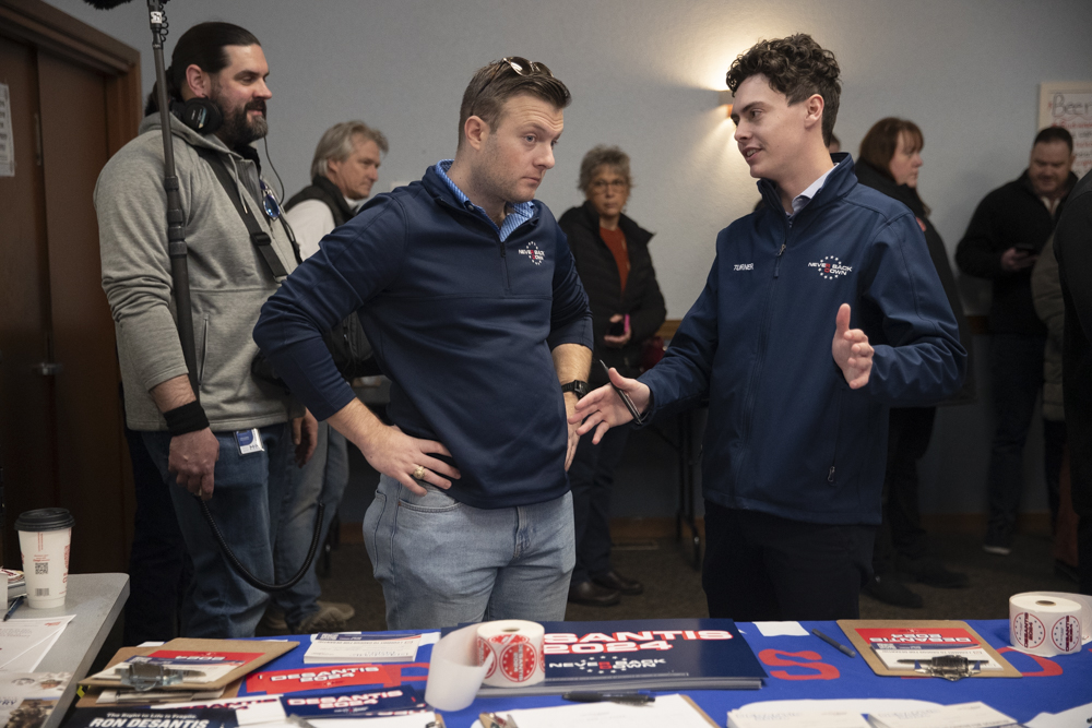 John McGrath and Nate Turner greet attendees at an event hosted by super PAC Never Back Down to promote Republican presidential candidate and Florida Gov. Ron DeSantis at the Veterans of Foreign Wars hall in Southwest Cedar Rapids on Tuesday, Dec. 19, 2023. 
