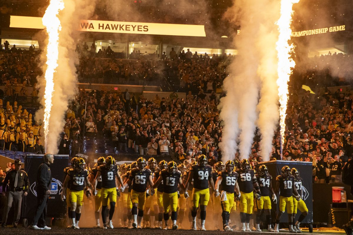 Iowa football pplayers and coaches walk onto the field before the Big Ten championship football game between No.18 Iowa and No. 2 Michigan at Lucas Oil Stadium in Indianapolis on Saturday, Dec. 2, 2023. The Wolverines defeated the Hawkeyes 26-0.