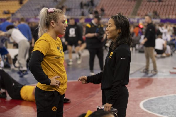 Iowa 116-pound Felicity Taylor talks to Iowa head coach Clarissa Chun before the semi-final round of the NWCA National Duals between No. 2 Iowa and King University on Saturday, Jan. 6, 2024. Iowa defeated King University, 39-4. 