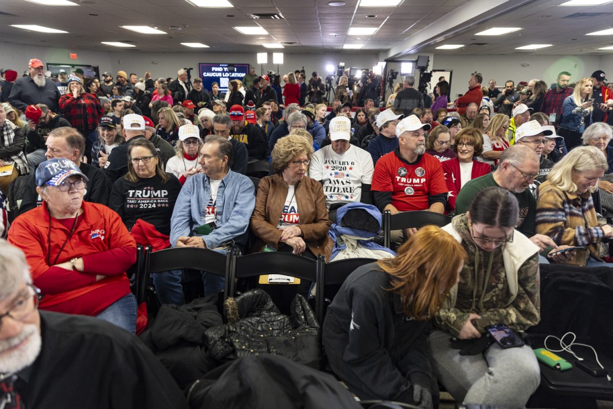Attendees wait for speakers to walk onto the stage during former President Donald Trump’s Commit to Caucus Rally at Des Moines Area Community College in Newton, Iowa on Saturday, Jan. 6, 2024. The Iowa caucuses take place on Jan. 15. Supporters filled the back of the room as attendees without reserved seats were asked to watch in a separate room.