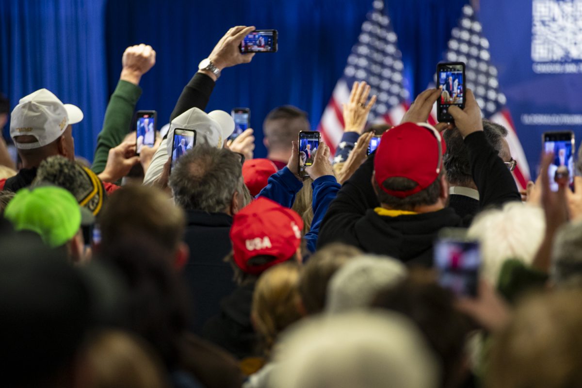 Attendees hold up their phones as former President Donald Trump enters the room during Trump’s Commit to Caucus Rally at Des Moines Area Community College in Newton, Iowa on Saturday, Jan. 6, 2024. The Iowa caucuses take place on Jan. 15. Several hundred people attended the event to hear Trump speak.
