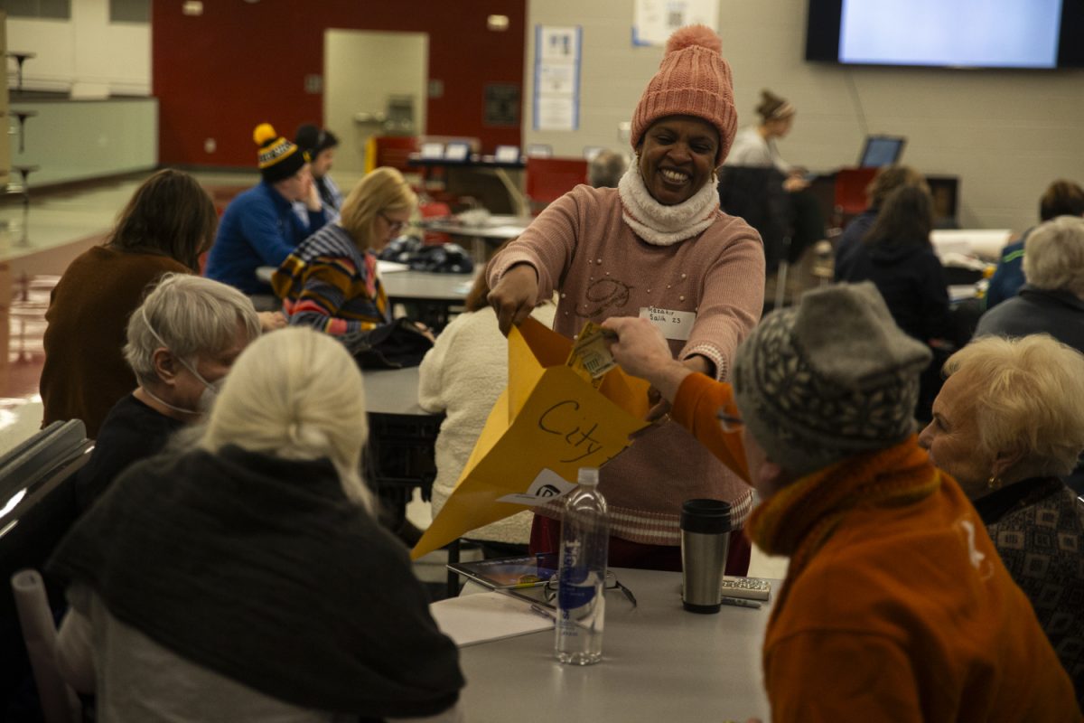 City council member Mazahir Salih collects donations from caucusgoers during the Iowa Democratic caucuses at City High School in Iowa City on Monday, Jan. 15, 2024. 