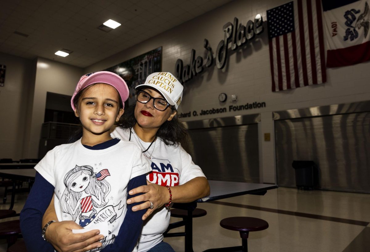 Maggi Sanchez and her daughter Catalina Davila-Sanchez,7, of Des Moines pose for a portrait before caucus begins at East High School in Des Moines on Monday, Jan. 15, 2024. Precinct Officials and volunteers set up as early caucus-goers entered the cafeteria. (Grace Smith/The Daily Iowan)