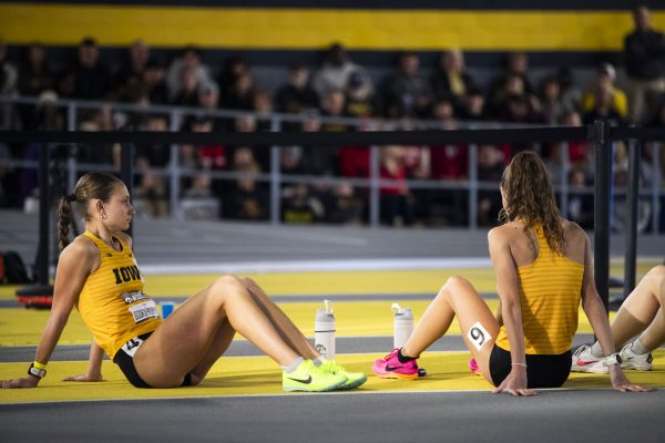Grace and Alli Bookin-Nosbisch rest before running the 800-meter during the Larry Wieczorek Invitational & Multi at the Hawkeye Indoor Track Facility in Iowa City on Saturday, Jan. 20, 2024.