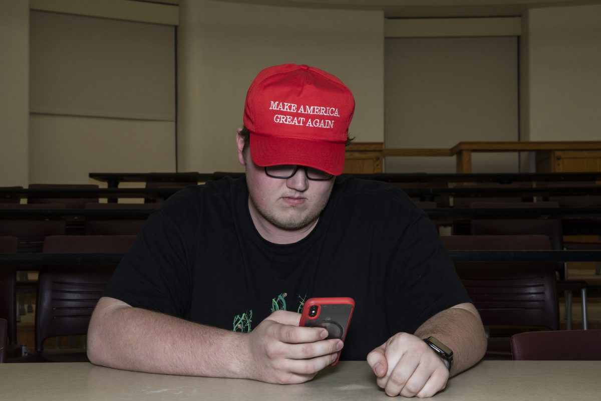 Caucus participant and University of Iowa freshman Mason Zaker checks his phone before a Republican caucus at Schaeffer Hall on February 3, 2020. The result of the locations preference poll was 14 votes for President Trump and 1 vote for former Illinois Congressman Joe Walsh. 