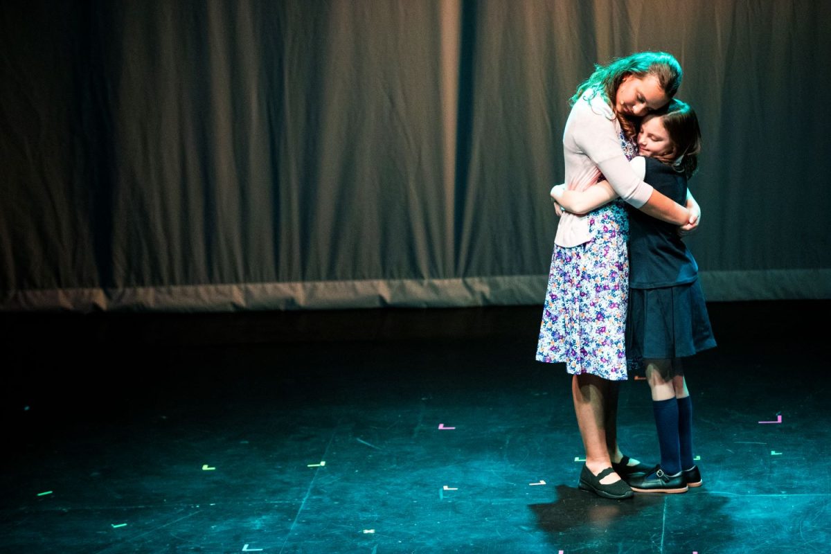Lyrah Huggins (left) and Bridget Greenwood (right) embrace during a performance of Matilda Jr. at the James Theater in Iowa City on Thursday, Feb. 1, 2024.