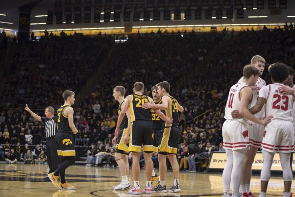 Members of the Iowa basketball team gather in a huddle during a mens basketball game between Iowa and Wisconsin at Carver-Hawkeye Arena on Feb. 17, 2024. The Hawkeyes defeated the Badgers in overtime, 88-86. 