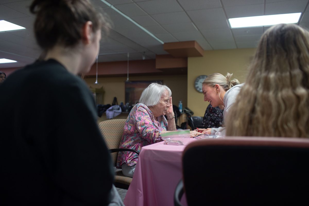 A volunteer laughs with a resident during a Glamour Gals event at Melrose Meadows on Sunday, Feb. 18, 2024. Glamour gals aims to go to one retirement home per month and paint resident’s nails and make crafts.  