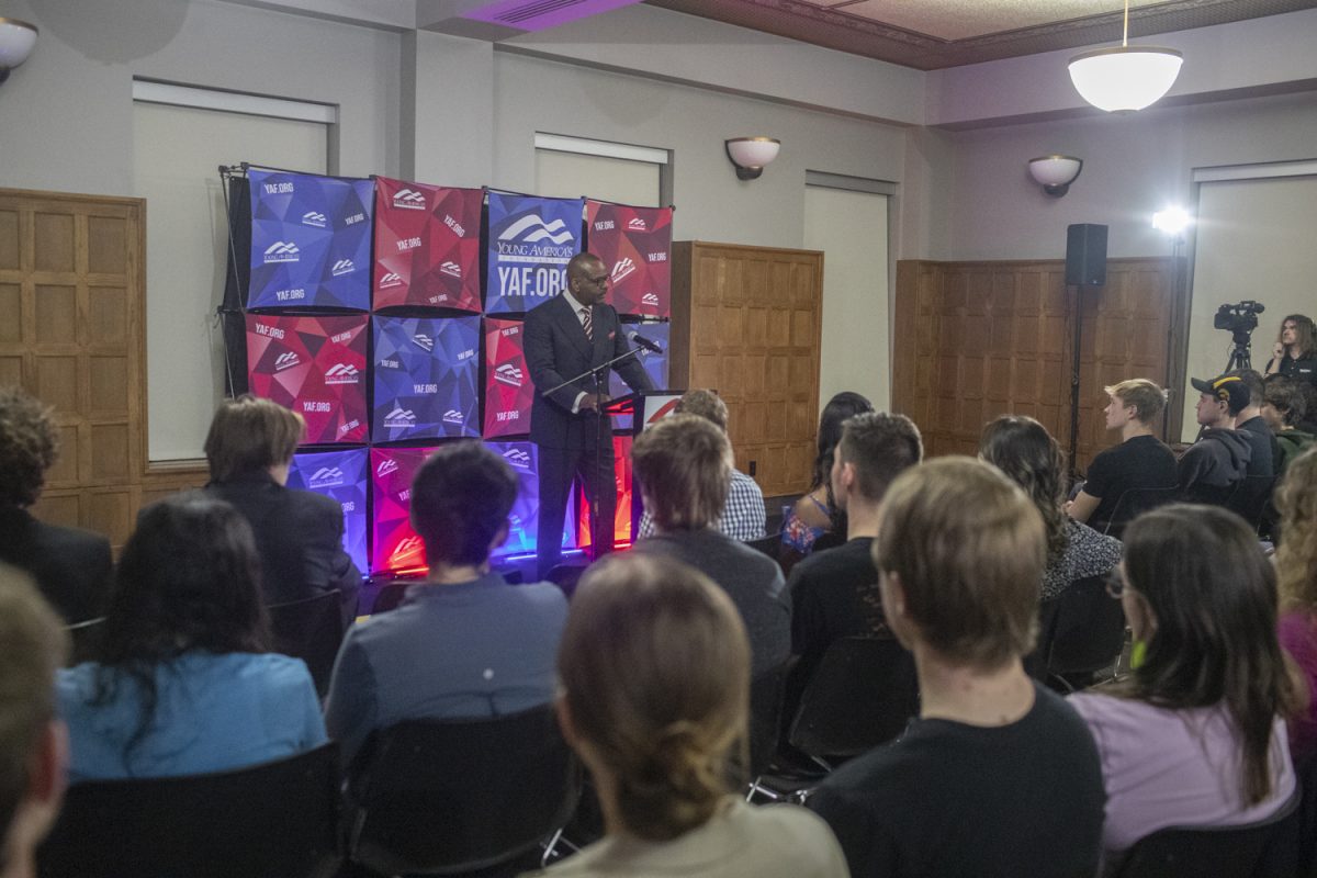 Vince Everett Ellison speaks during a guest lecture at the IMU on Monday, Feb. 26, 2024. Ellison is a conservative speaker invited by YAF who opposes DEI and abortion. Roughly two dozen protesters played a “bingo board” made out of Ellison’s talking points.