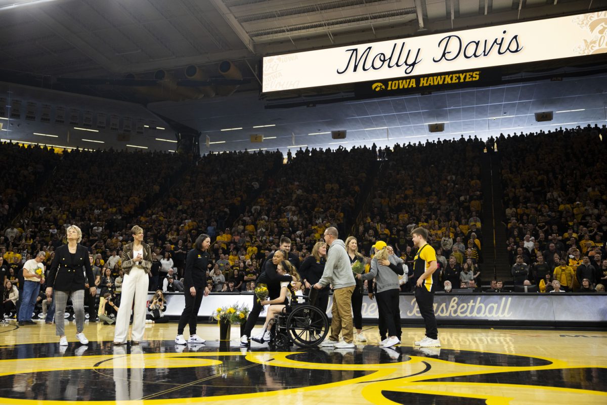 Iowa guard Molly Davis hugs assistant coach Raina Harmon during a basketball game with No. 6 Iowa and No. 2 Ohio State inside a sold-out Carver-Hawkeye Arena in Iowa City, Iowa, on Sunday, March 3, 2024. The Hawkeyes upset the Buckeyes, 93-83, on senior night.