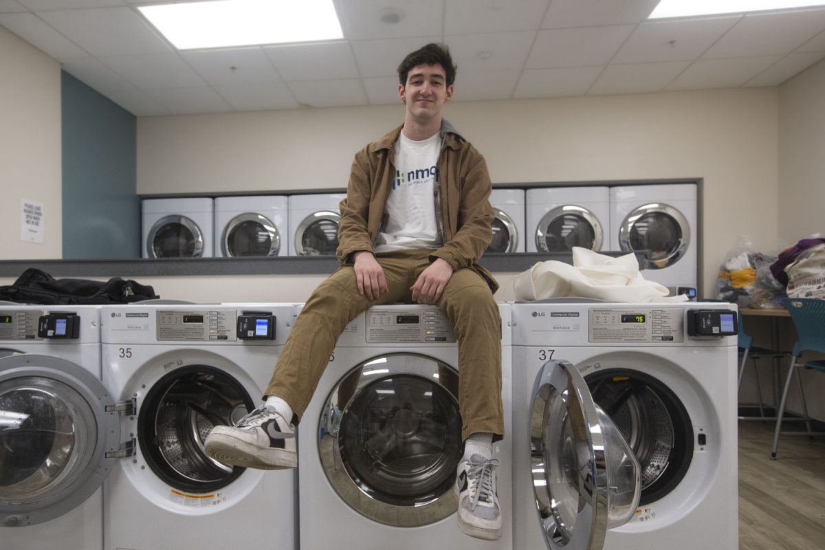 Carter Fitzgerald, a winner of the Spring IdeaStorm competition, poses for a portrait in front of the laundry that he seeks to make more efficient, on Monday, March 13, 2024. Fitzgerald is a first-year Finance student at the University of Iowa, and won $500 in February for his proposal to use laundry data to create a laundry tracking app.