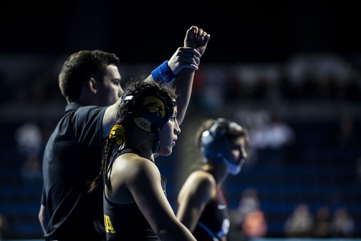 An official holds up Iowa 101-pound Emilie Gonzalez hand after defeating Simon Fraser University Gina Bolognese during the first day of the National Collegiate Women’s Wrestling Championships at Alliant Energy PowerHouse in Cedar Rapids, Iowa on Friday, March 8, 2024. Gonzalez won by technical fall.